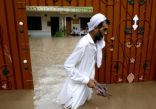 رجل يسير في مياه الفيضانات بعد هطول الأمطار الغزيرة في بيشاور.